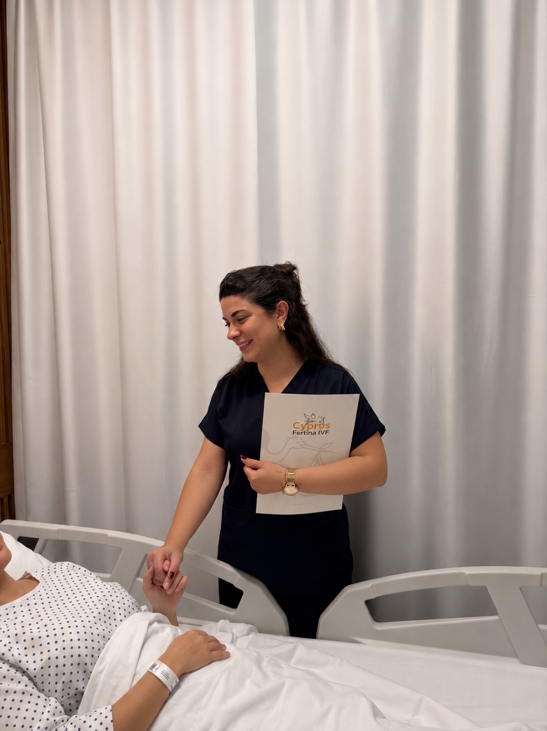 Une infirmière de Fertina tenant la main d'une patiente à son chevet